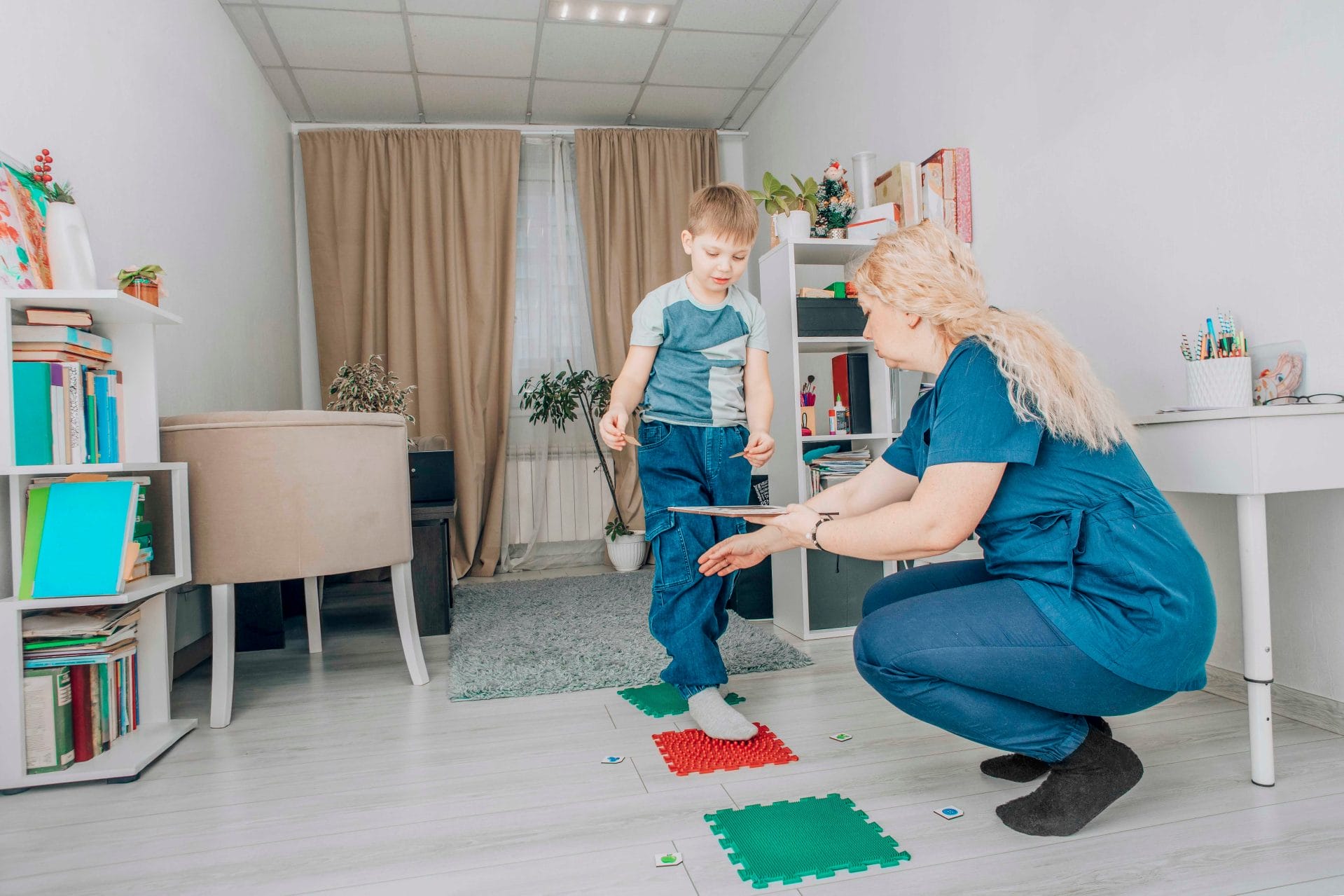 Adult and child engaging in therapy or physical activity on a mat.