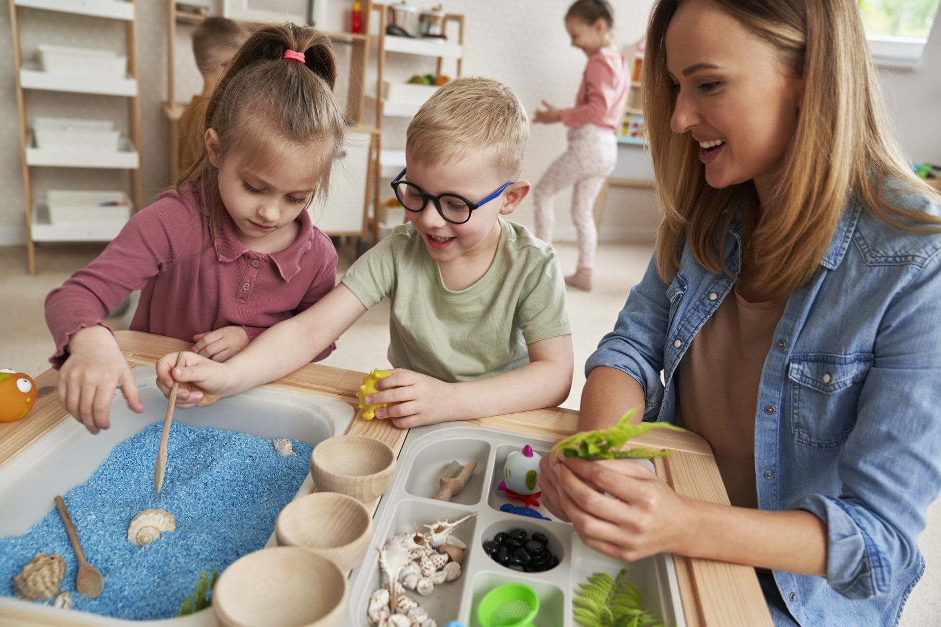 Teacher guiding children through a hands-on science activity.