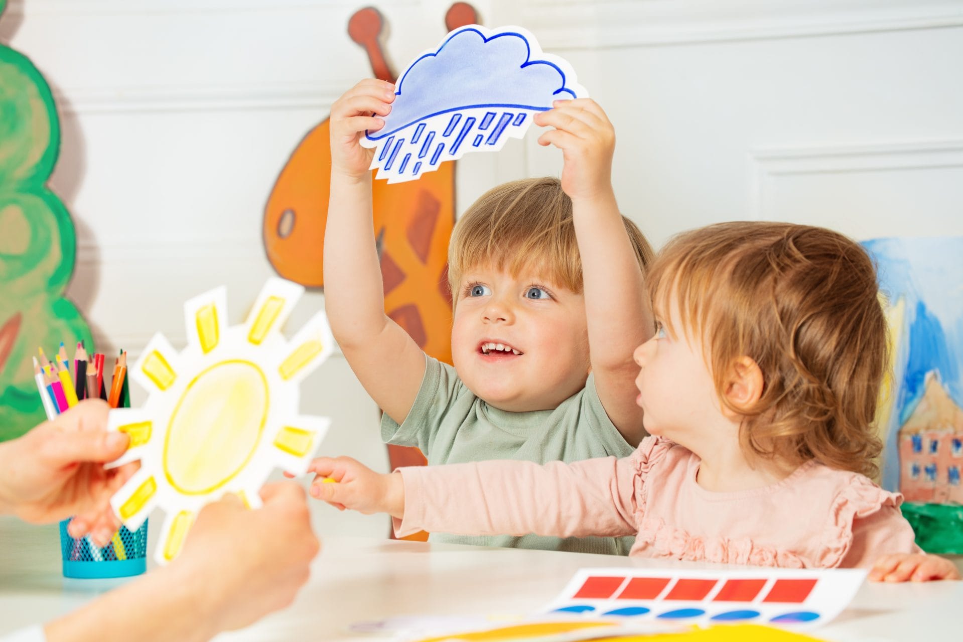 Two toddlers painting with their hands during an art activity.